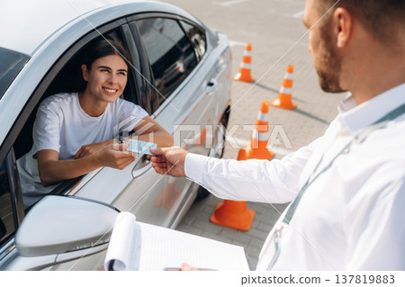 Congratulations giving the license, passed. Woman is trying to pass exam in the driving school Congratulations giving the license, passed. Woman is trying to pass exam in the driving school 137819883
