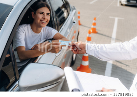 Congratulations giving the license, passed. Woman is trying to pass exam in the driving school Congratulations giving the license, passed. Woman is trying to pass exam in the driving school 137819885