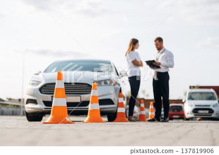 Man instructor in the driving school and woman are outside the car 137819906