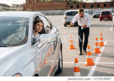 Helping to park the car. Woman is trying to pass exam in the driving school 137819907