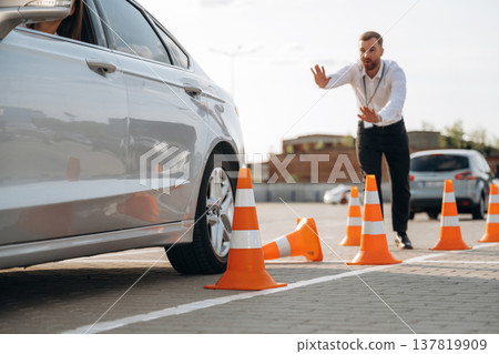 Helping to park the car. Woman is trying to pass exam in the driving school Helping to park the car. Woman is trying to pass exam in the driving school 137819909