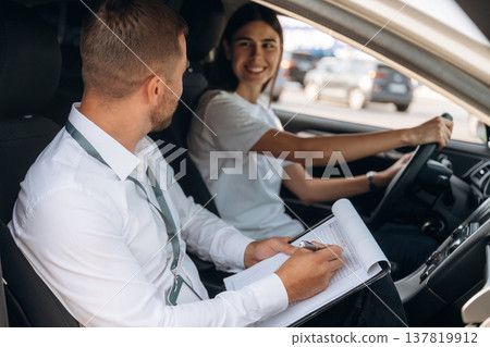 Side view. Woman is with instructor in car, driving school concept 137819912