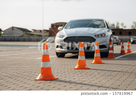 Car is on the parking lot with orange colored cones, driving school conception Car is on the parking lot with orange colored cones, driving school conception 137819967