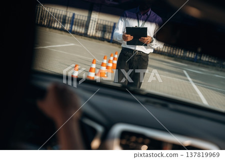 View from the car. Woman is trying to pass exam in the driving school View from the car. Woman is trying to pass exam in the driving school 137819969