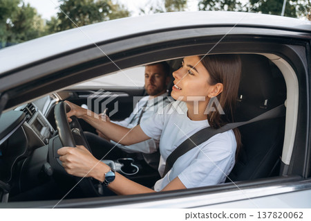 Looking for a way, driving. Woman is with instructor in car, driving school concept Looking for a way, driving. Woman is with instructor in car, driving school concept 137820062