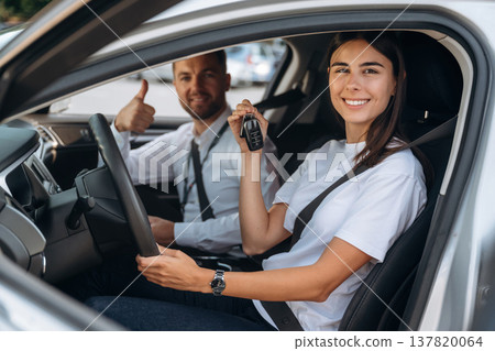 Woman is with instructor in car, driving school concept Woman is with instructor in car, driving school concept 137820064