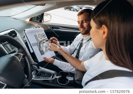 Visual tests. Woman is with instructor in car, driving school concept Visual tests. Woman is with instructor in car, driving school concept 137820076
