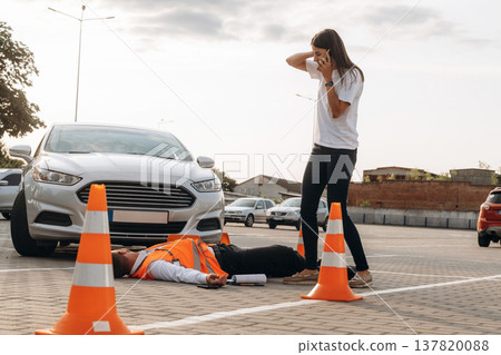 Calling the ambulance. Horrible crash, woman hit a man that is lying down on the road Calling the ambulance. Horrible crash, woman hit a man that is lying down on the road 137820088