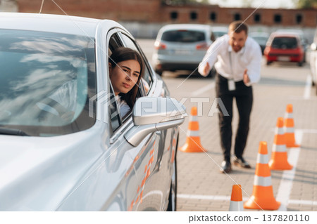 Parking exercise. Woman is trying to pass exam in the driving school 137820110