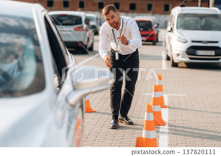 Parking exercise. Woman is trying to pass exam in the driving school Parking exercise. Woman is trying to pass exam in the driving school 137820111