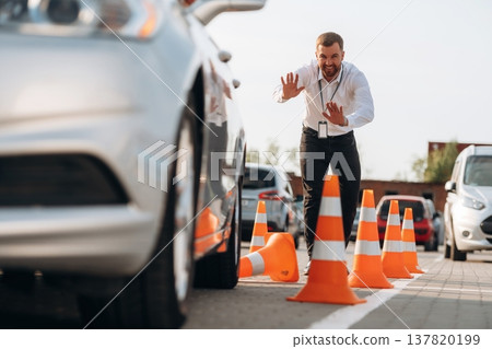 Driving school instructor is controlling the parking of a car Driving school instructor is controlling the parking of a car 137820199