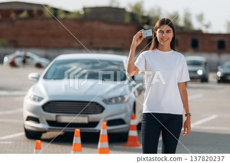 Happy woman is holding her driving license, driving school test passed Happy woman is holding her driving license, driving school test passed 137820237