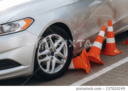 Car is on the parking lot with orange colored cones, driving school conception Car is on the parking lot with orange colored cones, driving school conception 137820249