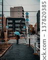 A person crossing a pedestrian crossing on a rainy street corner. 137820385