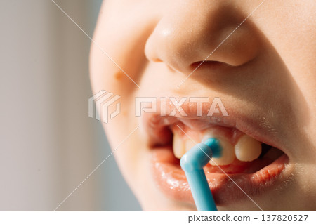 Child cleaning teeth with single tuft toothbrush, close up dental care concept 137820527