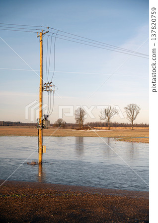 Spring melting leads to flooding near power lines and bare trees Spring melting leads to flooding near power lines and bare trees 137820759