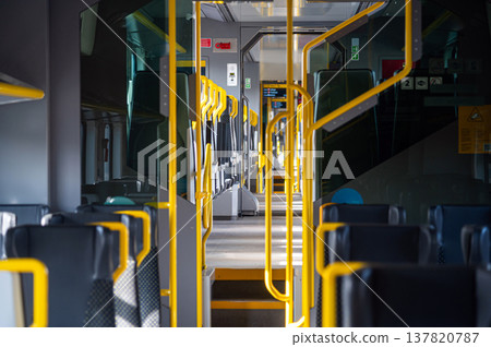Train interior with empty seats and clear view of the aisle during daytime Train interior with empty seats and clear view of the aisle during daytime 137820787