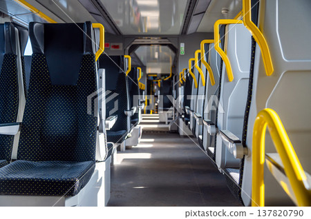 Seats are empty on a modern train during daytime travel in a city 137820790