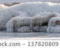 Winter ice covers rocks along a frozen body of water in a cold environment 137820809