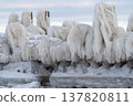 Winter weather creates icy formations on a shoreline near a lake at dawn 137820811