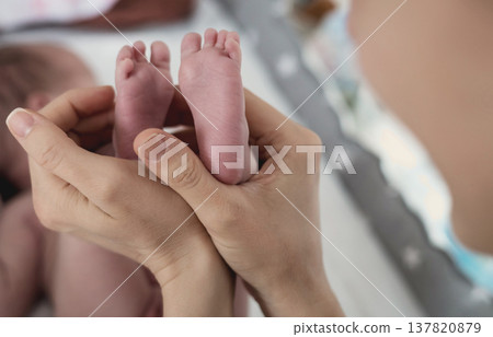 Parent holding in the hands feet of newborn baby. Parent holding in the hands feet of newborn baby. 137820879