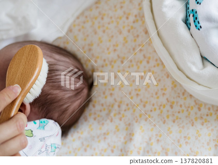 Parent grooming infant with natural hair brush 137820881