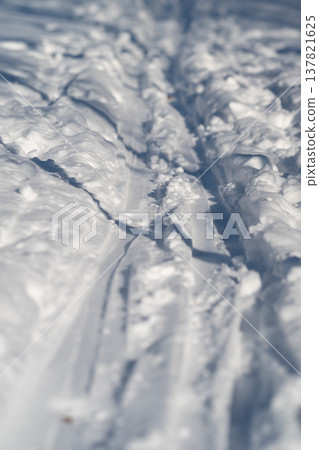 Rutted snow ski trail showing recent passage, churned grooves and compressed edges, trail maintenance or sledder impression, gritty texture and activewellness undertone Rutted snow ski trail showing recent passage, churned grooves and compressed edges, trail maintenance or sledder impression, gritty texture and activewellness undertone 137821625