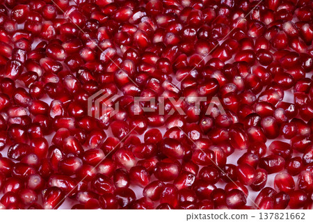 Closeup pomegranate seeds glistening with deep ruby tones, glossy surfaces, dense packed composition, perfect for luxury food styling or chef ingredient imagery 137821662