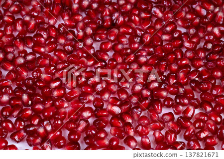 Fresh red seeds emphasize nutrition and freshness appeal. Luscious pomegranate fruits packed with potent antioxidants and vividly colored seeds highlight health benefits Fresh red seeds emphasize nutrition and freshness appeal. Luscious pomegranate fruits packed with potent antioxidants and vividly colored seeds highlight health benefits 137821671