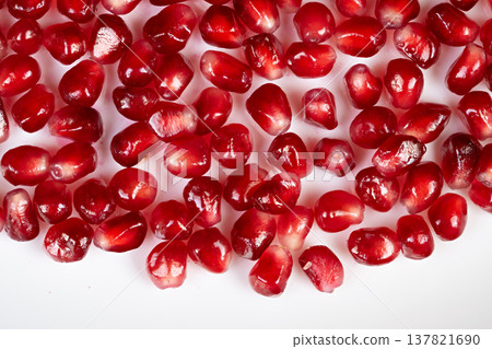 Pomegranate seeds arranged artistically on plate edge. Elegant plating with pomegranate seeds artistically positioned along rim for visual appeal and seasonal flavor highlight Pomegranate seeds arranged artistically on plate edge. Elegant plating with pomegranate seeds artistically positioned along rim for visual appeal and seasonal flavor highlight 137821690