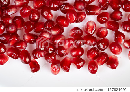 Bright red pomegranate seeds add sparkle to holiday treats and drinks. Vivid pomegranate seeds create lively accents on cocktails and sweet dishes during festivities 137821691