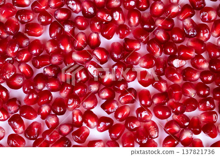 Jewelrylike fruit adornment. Closeup of luxurious pomegranate seed decoration. Magnificent presentation of glistening pomegranate seeds designed for upscale food packaging Jewelrylike fruit adornment. Closeup of luxurious pomegranate seed decoration. Magnificent presentation of glistening pomegranate seeds designed for upscale food packaging 137821736