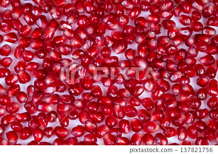 Background created by vibrant ruby seeds in macro detail. High contrast studio shot capturing repetitive shimmering pattern of pomegranate seeds in closeup 137821756
