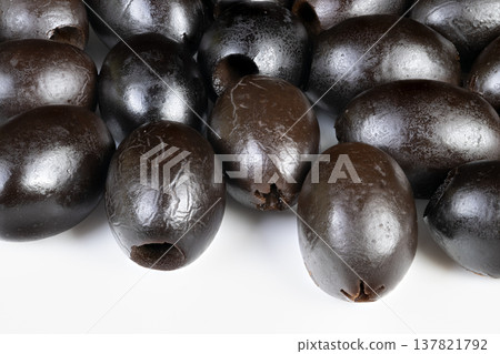 Minimalist composition emphasizing shiny surface and detailed skin. Tightly cropped image capturing glossy black olives with subtle reflective highlights and detailed skin texture 137821792