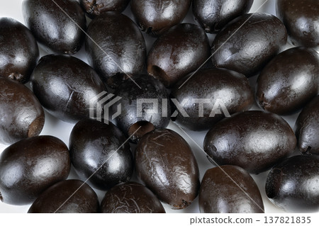 Glistening black olives with natural skins. Packed black olives showcase rich texture and oil. Closepacked clusters of shining olives reveal organic freshness and flavor 137821835