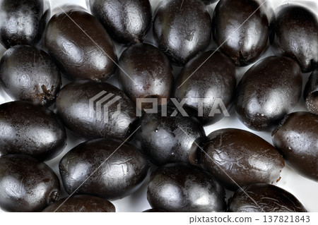 Shiny olives prepared. Fresh dark olives with gloss. Brightly shining olives with oil coating. Lustrous black olives featuring glossy surface ready for culinary uses 137821843