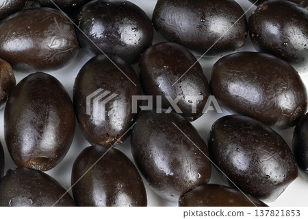 Mature black olives exhibiting fresh appearance and dewy surface. Ripened black olives displaying fresh look with subtle water droplets perfect for market displays Mature black olives exhibiting fresh appearance and dewy surface. Ripened black olives displaying fresh look with subtle water droplets perfect for market displays 137821853