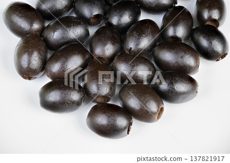 Group of ripe black olives ready for blending or spreading tasks. Tightly packed collection of black olives prepared for tapenade or paste creation in kitchen still life setting Group of ripe black olives ready for blending or spreading tasks. Tightly packed collection of black olives prepared for tapenade or paste creation in kitchen still life setting 137821917