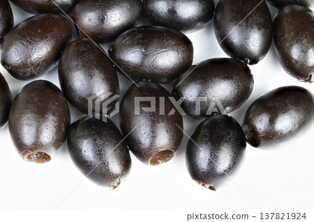 Glossy black olives on bright background. Closeup view of shiny black olives with brine. Macro photograph capturing lustrous black olives with hint of salty brine sheen Glossy black olives on bright background. Closeup view of shiny black olives with brine. Macro photograph capturing lustrous black olives with hint of salty brine sheen 137821924
