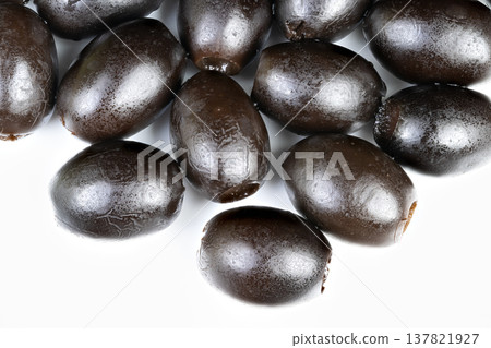 Arrangement of black olives designed for food photography in empty space. Black olives meticulously placed for culinary shot emphasizing bright white negative area 137821927
