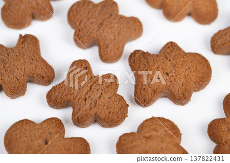 Spiced cookies on bright surface. Closeup of aromatic baked cookies with textured tops. Macro image showcasing flavored brown cookies arranged randomly under warm lighting Spiced cookies on bright surface. Closeup of aromatic baked cookies with textured tops. Macro image showcasing flavored brown cookies arranged randomly under warm lighting 137822431
