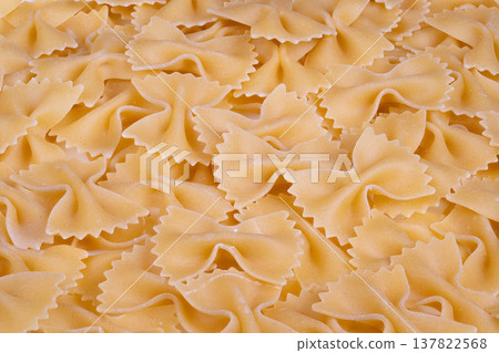 Farfalle shapes create textured design. beige pasta texture with detailed edges. Repetitive bowshaped pasta silhouettes form uniform pattern background Farfalle shapes create textured design. beige pasta texture with detailed edges. Repetitive bowshaped pasta silhouettes form uniform pattern background 137822568
