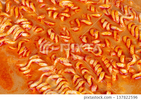 Spicy noodle appeal. Closeup shot emphasizing spicy noodles with seasonings and shine. Detailed view showcasing vibrant textures and toppings of spicy noodles for marketing 137822596