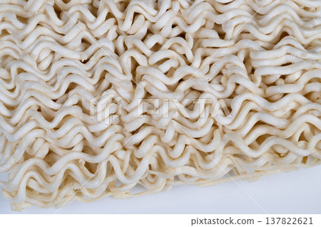 Dry instant noodles grid photographed in industrial style, repetitive waves and uniform shapes, sterile backdrop suggests mass production and quality control scenarios Dry instant noodles grid photographed in industrial style, repetitive waves and uniform shapes, sterile backdrop suggests mass production and quality control scenarios 137822621