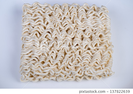 White background showcasing neatly arranged dry instant noodles package. Studio shot of compact square dry instant noodles with balanced illumination and clear focus White background showcasing neatly arranged dry instant noodles package. Studio shot of compact square dry instant noodles with balanced illumination and clear focus 137822639