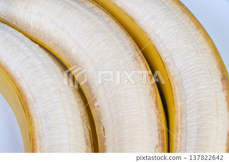 Ripe peeled bananas closeup arranged as snack portions, fresh moist surface, bright natural light, inviting warm palette, emphasizes nutrition, softness and biteready texture 137822642