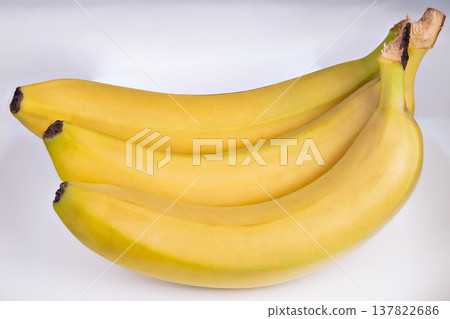 Ripe bananas bunch on clean white background, even studio lighting, shadow separation for product listing and menu imagery, focus on shape and color for commercial use 137822686