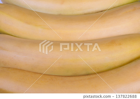 Ripe bananas closeup textured yellow skin, subtle brown freckles, soft matte sheen, tight crop emphasizing curvature and natural pattern, vivid food photography mood 137822688