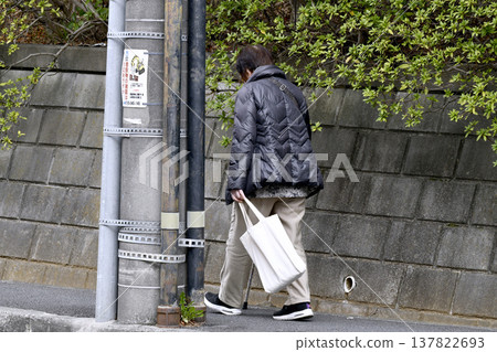 一張日本橫濱的城市景觀照片……一位拄著拐杖（戴著口罩）的老婦人低著頭走在人行道上……人生究竟是什麼……？ = 橫濱市 137822693