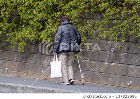 A picture of the cityscape of Yokohama, Japan...an elderly woman with a cane (wearing a mask) walking on the sidewalk with her head down...what is life...? = Yokohama city A picture of the cityscape of Yokohama, Japan...an elderly woman with a cane (wearing a mask) walking on the sidewalk with her head down...what is life...? = Yokohama city 137822696